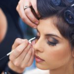 Shes meticulous with her make up. A young woman having makeup applied.