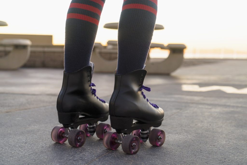 Mid adult woman on rollerskates, rear view, low section
